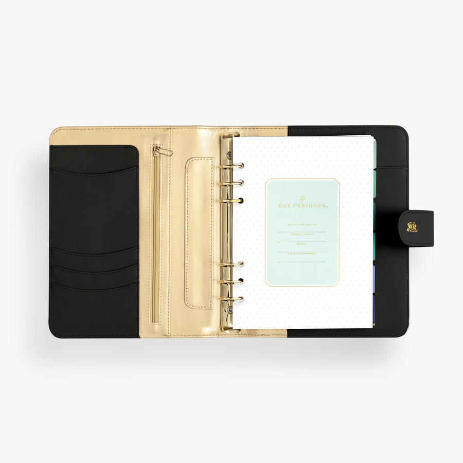 A5 black binder open to show black and gold lining with pockets, stickers, and colorful insert pages