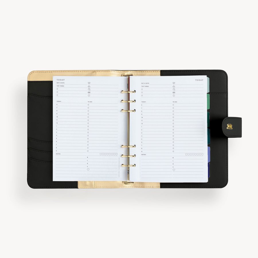 A5 black binder open to show black and gold lining with daily planning pages