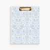 repeated light blue and gold classic pattern clipfolio with gold clip on a cream background
