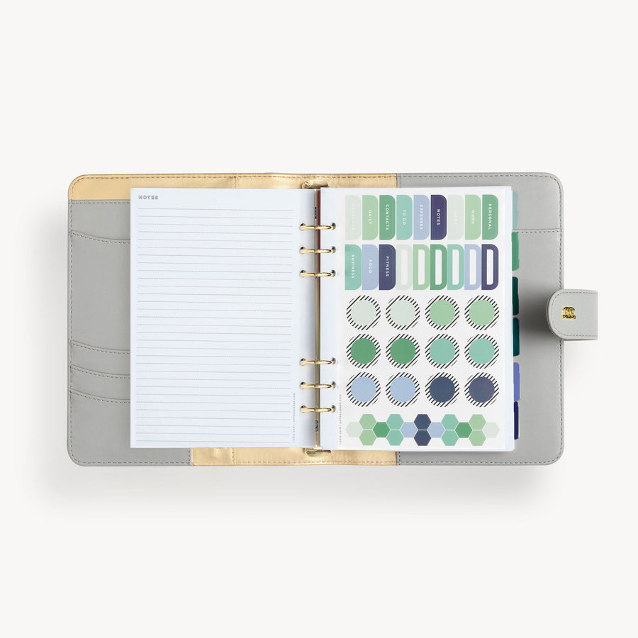 A5 gray binder open to show gray and gold liner with notes page and colorful stickers