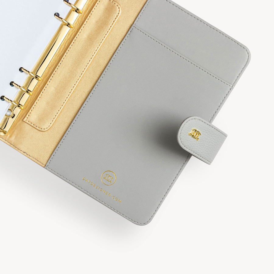 Gray A5 binder open to show gray and gold lining with pocket and gold binding