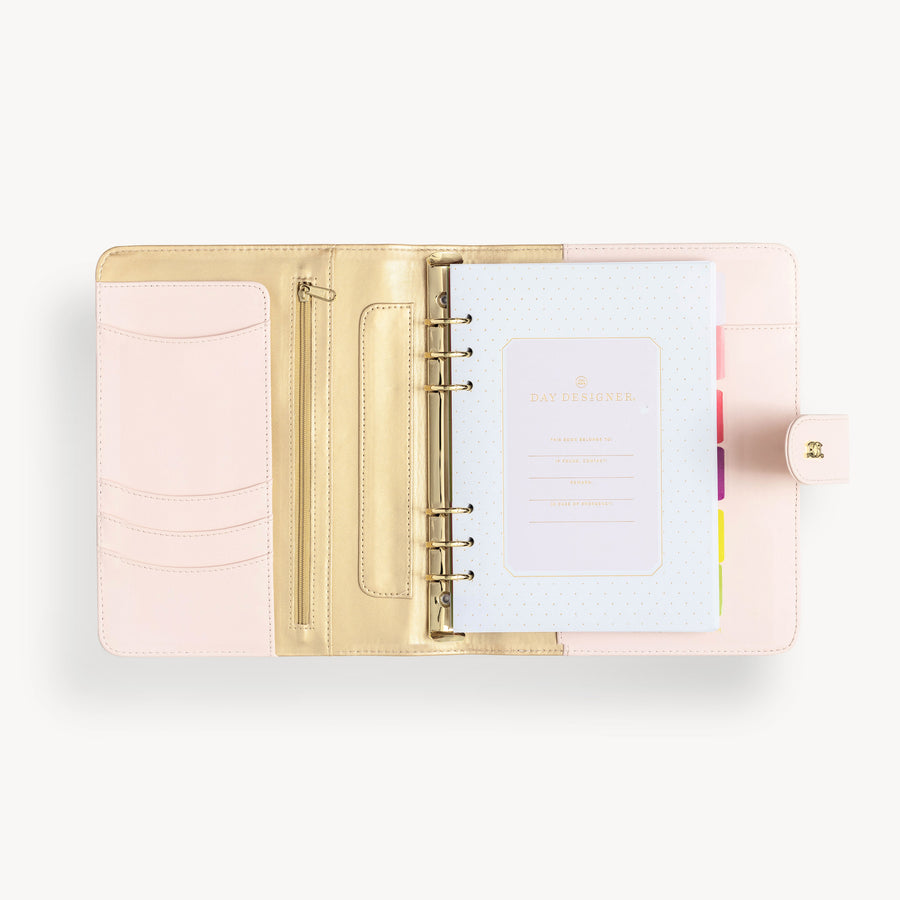 Blush binder open to show blush and gold interior with pockets and zipper and colorful starter pack insert pages
