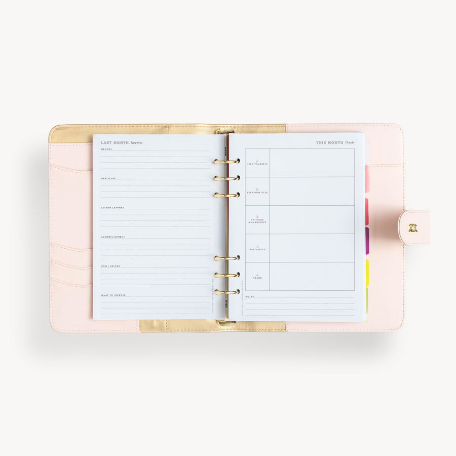 Blush binder open to show blush and gold interior with pockets and zipper and colorful goal setting insert pages