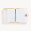 Blush binder open to show blush and gold interior with pockets and zipper and daily pages