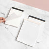 Three planning notepads on a marble background