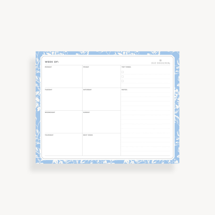 weekly planning pad with blue floral border on a white background