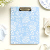 light blue clipfolio with pretty white flowers and gold clip, on a cream background