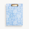 light blue clipfolio with pretty white flowers and gold clip, on a light cream background