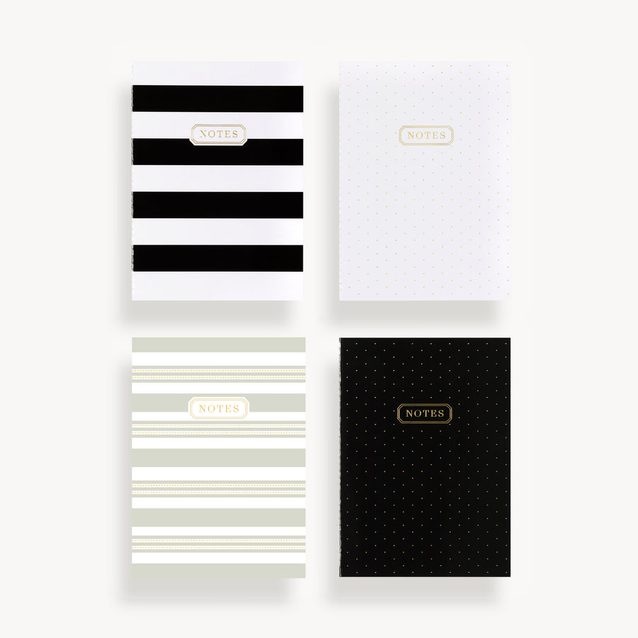set of four slim mini notebooks with four black, white, and gray different cover patterns and gold title accent