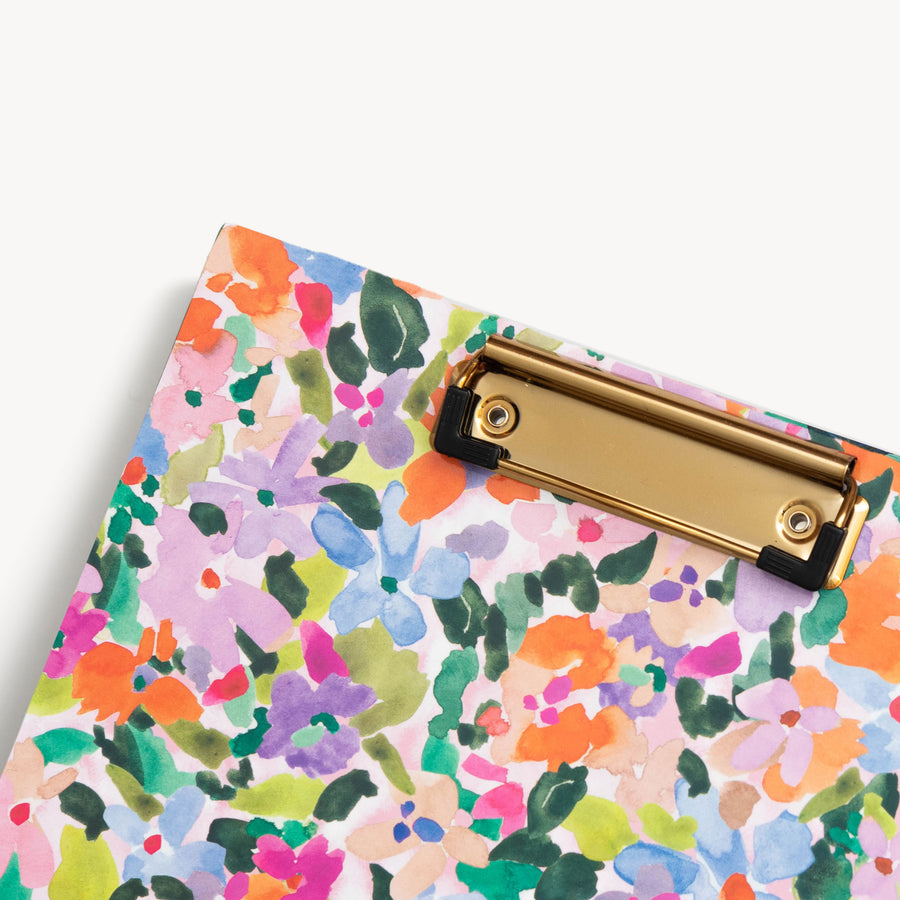 close up colorful floral pattern clipfolio with gold clip on a cream background