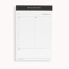 Planning pad with black and gold trim and undated daily planning layout.