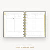 An open spiral-bound daily planner showing two lined daily planning pages with gold ring binding, photographed on a clean white background with the text 'DAILY PLANNING PAGE' below.