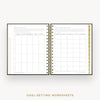 An open spiral-bound planner or notebook showing two pages of goal-setting worksheets, with a gold-toned ring binder and gold vertical tabs, on a light gray background. Text below reads 'GOAL-SETTING WORKSHEETS'.