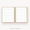 An open spiral-bound planner showing a 12-month calendar overview on white pages, with a gold wire binding and gold page edges, centered on a light gray background. Text below reads '12-MONTH OVERVIEW'.