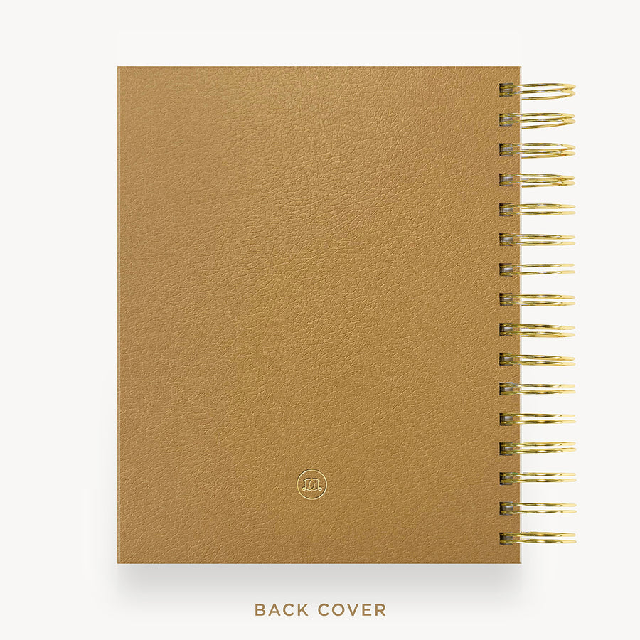 A tan textured spiral-bound notebook shown from the back, with gold-toned wire binding along the right edge and the words 'BACK COVER' printed below on a light gray background.