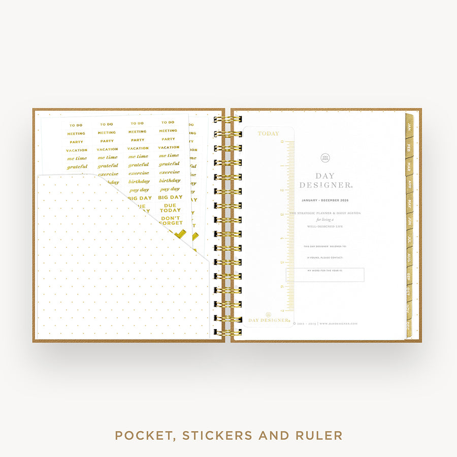 An open spiral-bound planner or pocket organizer shown on a light gray background, with gold-toned lettering and divider pages visible inside. Text below reads 'POCKET, STICKERS AND RULER'.