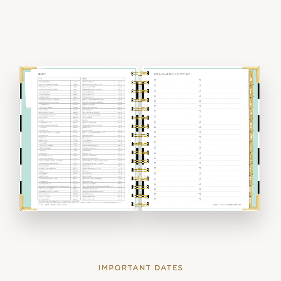An open spiral-bound planner or agenda on a light gray background, showing a detailed monthly calendar page with columns for days, notes, and checkboxes. The planner has gold-toned rings, white pages, and pastel side tabs.