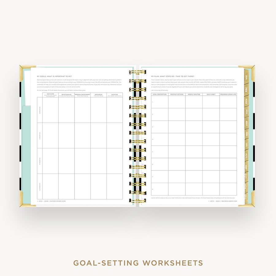 An open spiral-bound planner or notebook showing two white goal-setting worksheet pages with black grid tables, gold ring binding, and a small mint-green tab on the left side, photographed on a light gray background with the text 'GOAL-SETTING WORKSHEETS' below.