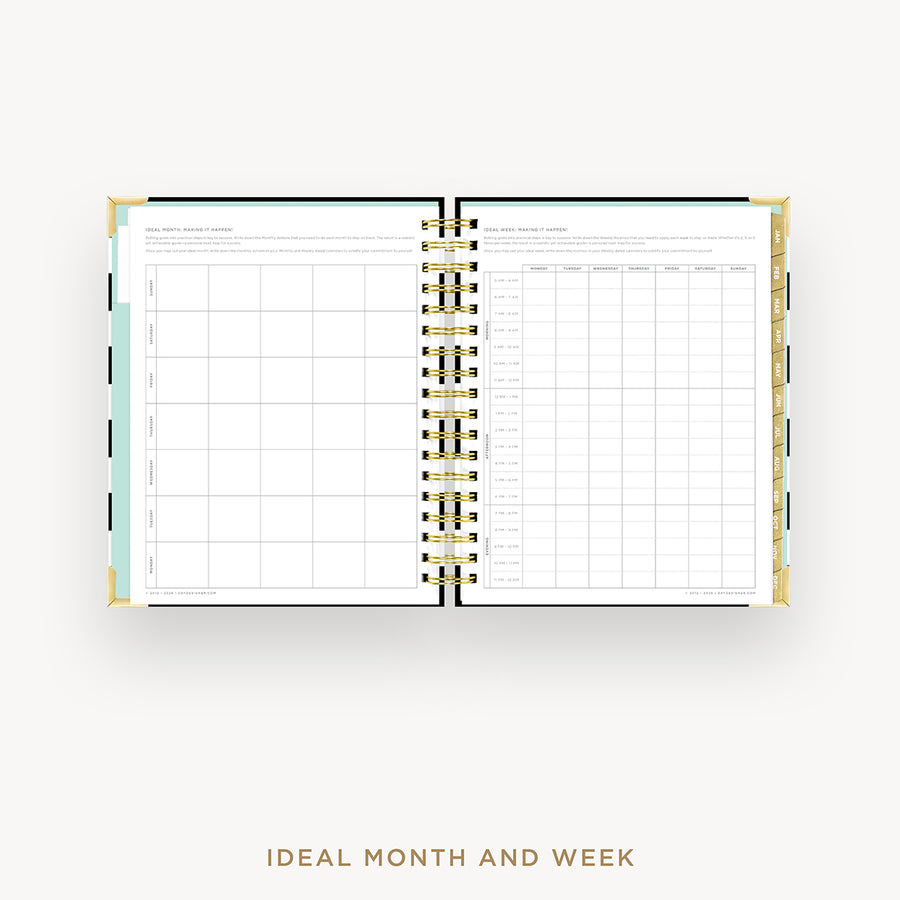An open spiral-bound planner or agenda showing a monthly and weekly calendar layout on white pages, photographed from above on a light gray background. The cover edges are gold, and the center binding is metallic gold with black rings.