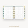 An open spiral-bound planner showing a 12-month overview calendar spread on a light gray background, with the text '12-MONTH OVERVIEW' below.