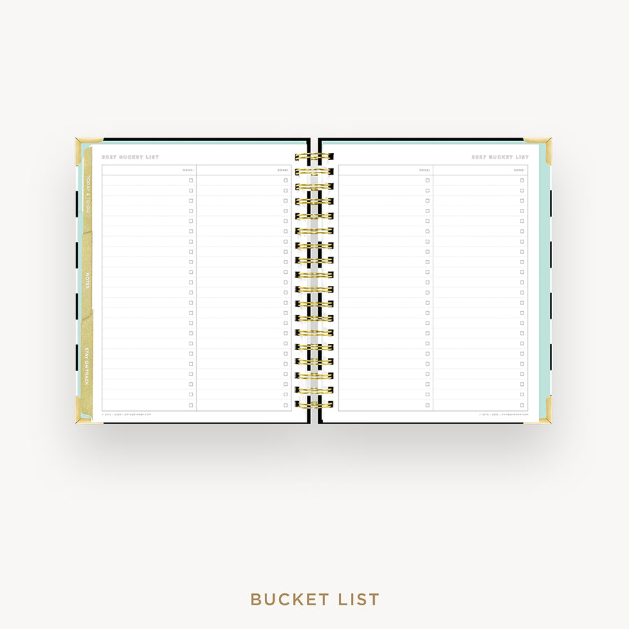 An open spiral-bound bucket list planner shown from above on a light gray background, with lined pages, gold rings, and pastel side accents. The text 'BUCKET LIST' appears below the planner.