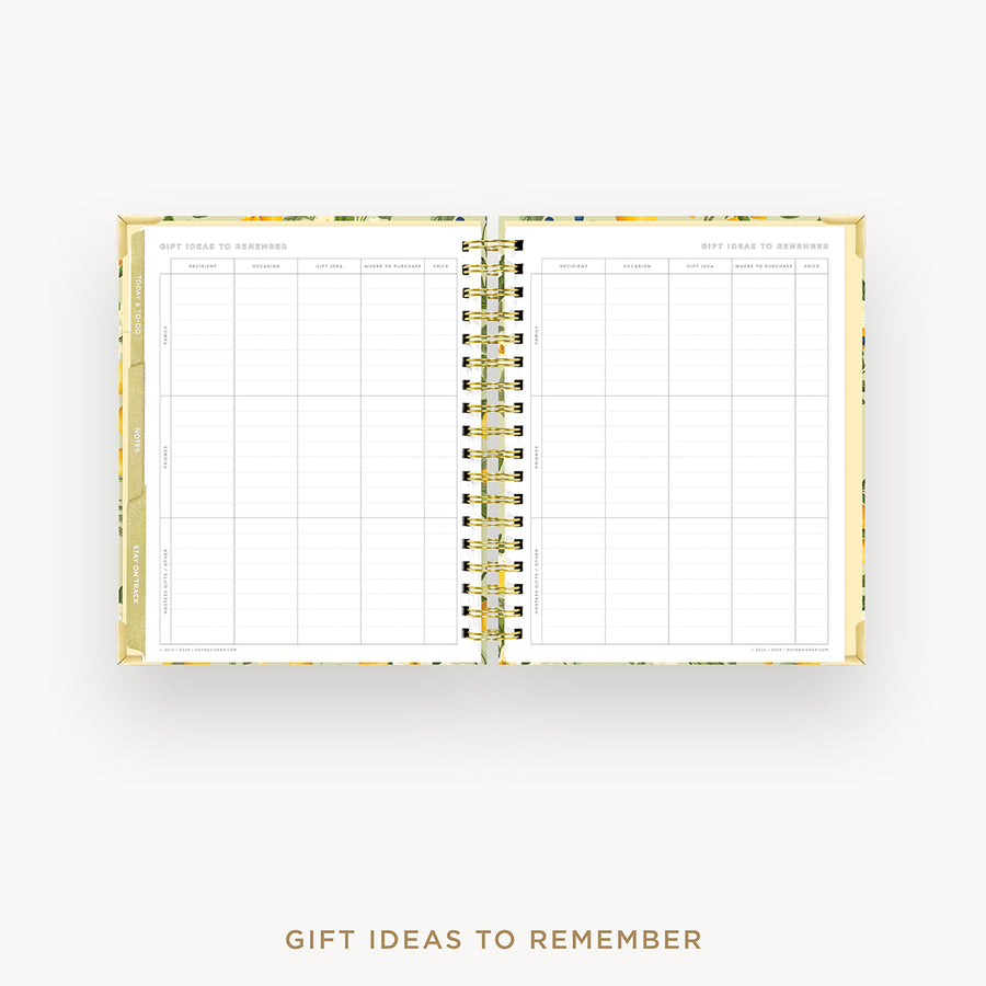 An open spiral-bound planner or notebook with two large white pages featuring a gift ideas to remember grid, shown on a light gray background with the title 'GIFT IDEAS TO REMEMBER' below.