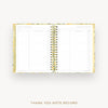 An open spiral-bound thank you note record planner with lined pages and a gold-toned metal coil, shown on a light gray background with the text 'THANK YOU NOTE RECORD' below.