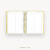 An open spiral-bound bucket list planner with lined pages and gold-toned binding, shown on a light gray background with the words 'BUCKET LIST' below.