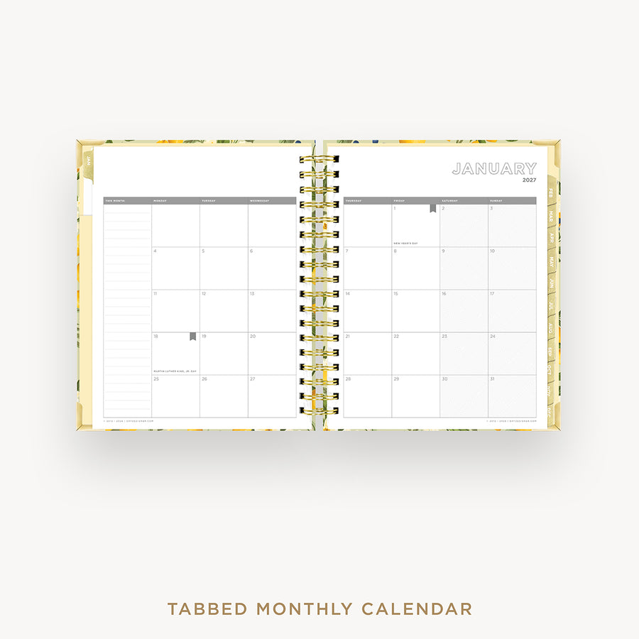 An open tabbed monthly calendar planner on a light gray background, showing a January 2027 calendar spread with gold spiral binding and a subtle floral pattern on the cover.