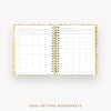An open spiral-bound planner or notebook showing printed goal-setting worksheets on the left and right pages, with a gold-toned spiral binding and a light floral-patterned cover. The text 'GOAL-SETTING WORKSHEETS' appears below on a plain light background.