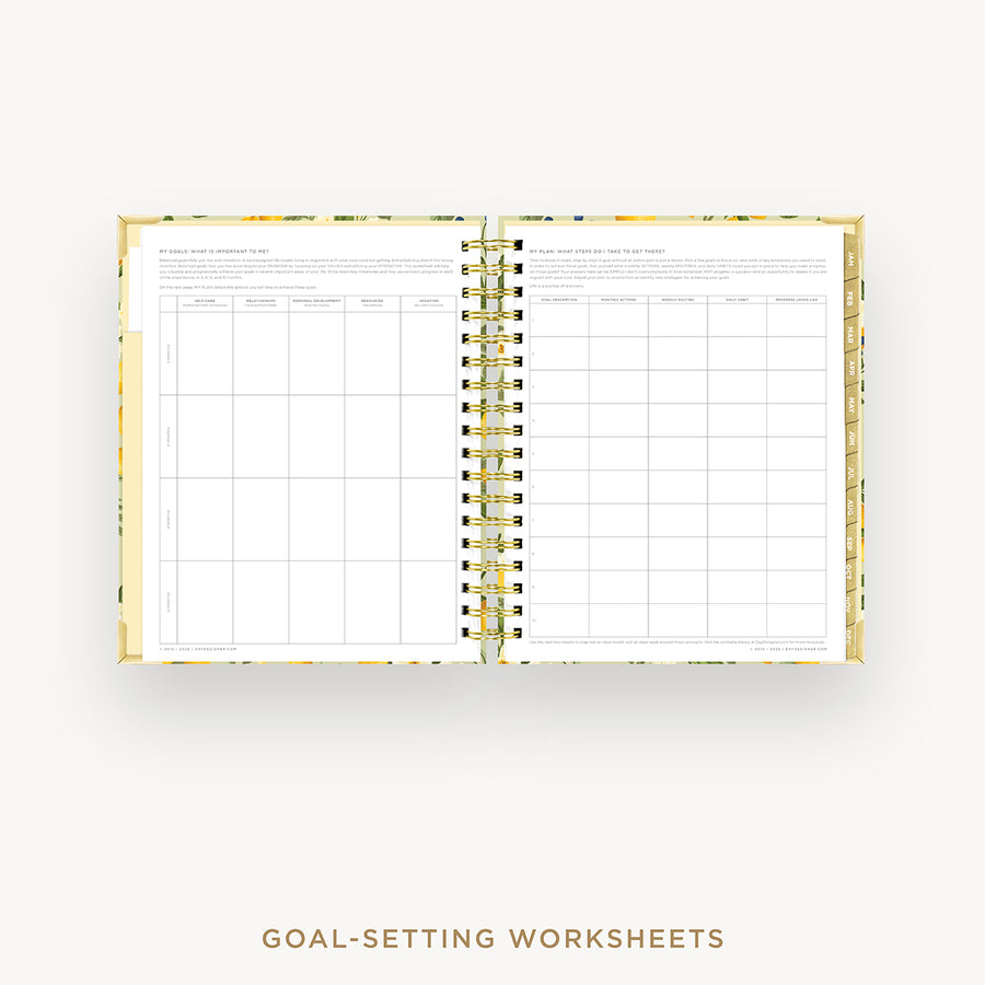An open spiral-bound planner or notebook showing printed goal-setting worksheets on the left and right pages, with a gold-toned spiral binding and a light floral-patterned cover. The text 'GOAL-SETTING WORKSHEETS' appears below on a plain light background.