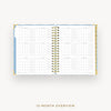An open spiral-bound 12-month planner or calendar showing a monthly overview layout, photographed on a light gray background with the text '12-MONTH OVERVIEW' below.