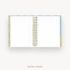 An open spiral-bound planner or notebook showing lined white notes pages, with a gold-toned binding and light blue and gold cover details, centered on a light gray background. The text 'NOTES PAGES' appears below.
