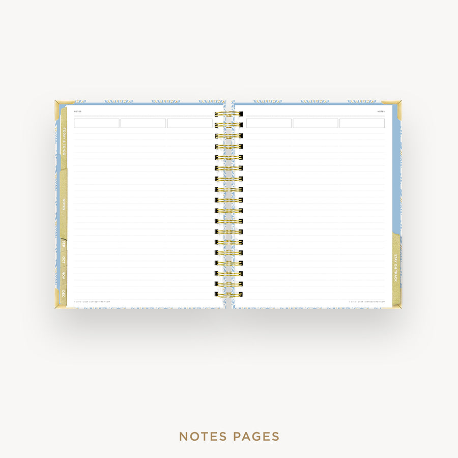 An open spiral-bound planner or notebook showing lined white notes pages, with a gold-toned binding and light blue and gold cover details, centered on a light gray background. The text 'NOTES PAGES' appears below.