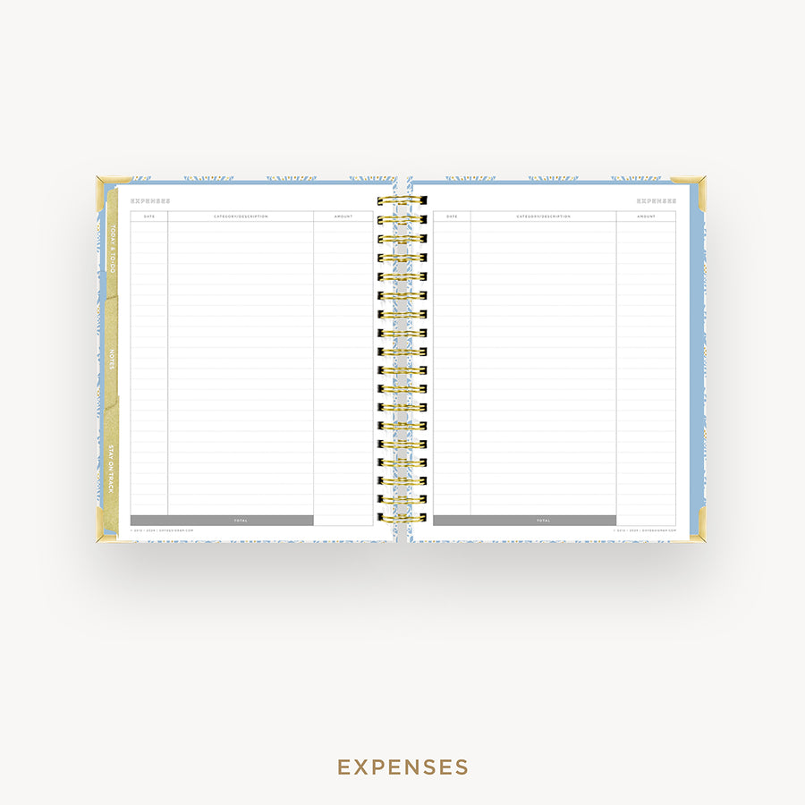An open spiral-bound planner showing the Expenses page with lined columns, photographed on a clean white background with the word EXPENSES below.
