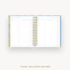 An open spiral-bound thank you note record planner with lined pages, gold rings, and a light blue and gold cover, shown on a light gray background with the text 'THANK YOU NOTE RECORD' below.
