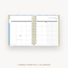 An open tabbed monthly calendar planner on a light gray background, showing the January 2027 page spread with gold spiral binding and blue page borders.
