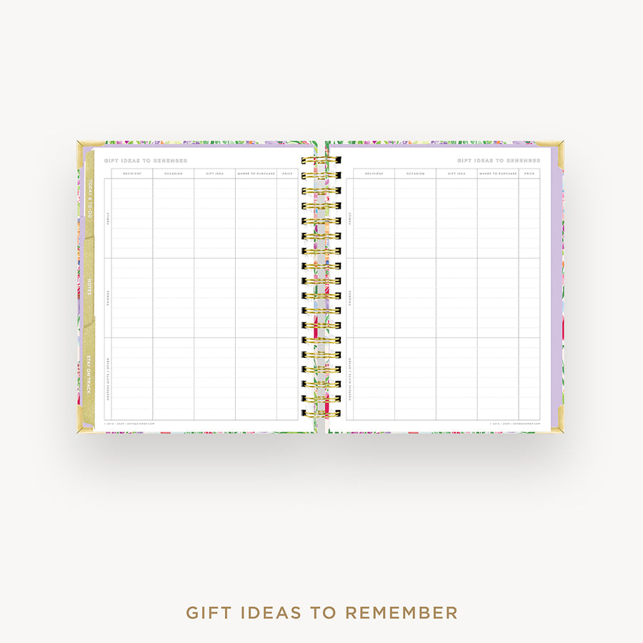 An open spiral-bound planner or notebook with a floral-patterned cover and white interior pages, shown on a light gray background with the text 'GIFT IDEAS TO REMEMBER' below.