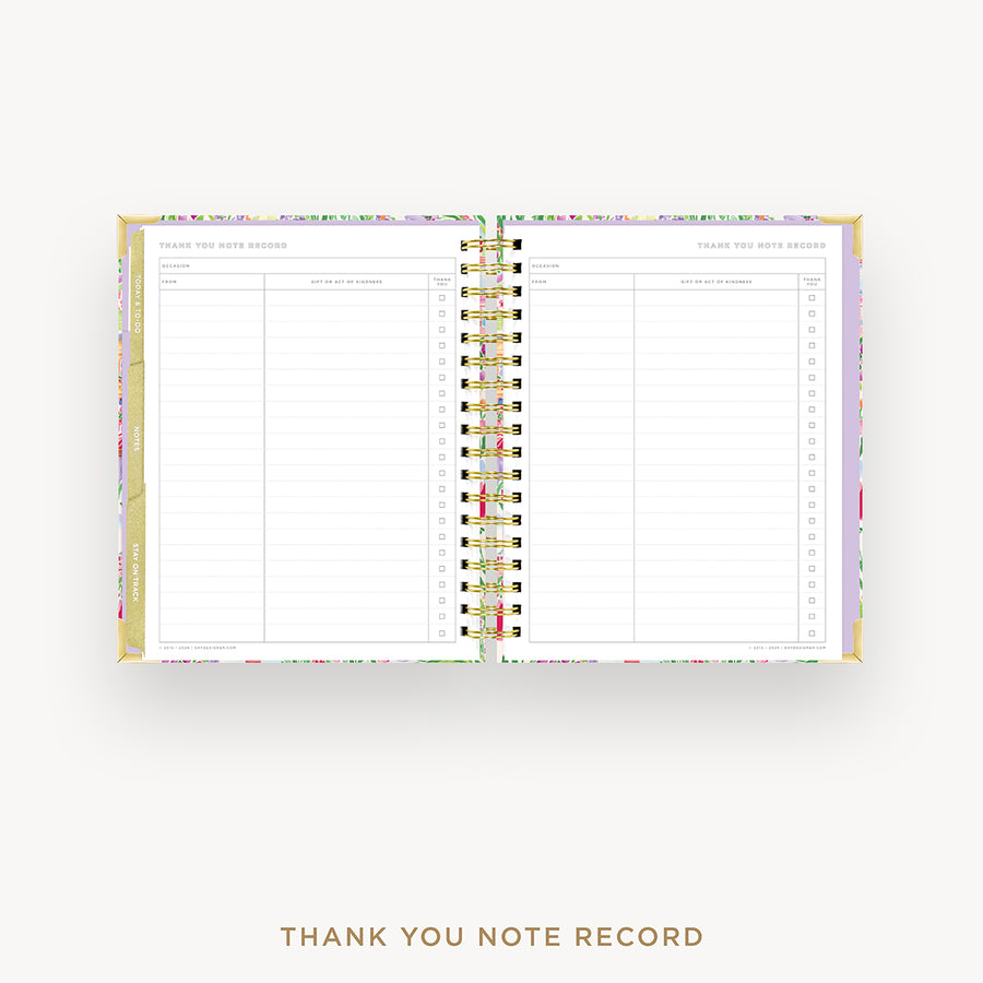An open spiral-bound thank you note record planner with lined pages, gold rings, and a pastel floral patterned cover, shown on a light gray background with the text 'THANK YOU NOTE RECORD' below.