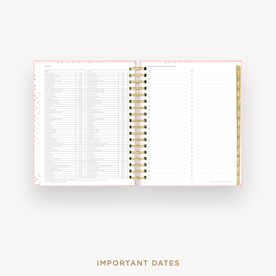 An open spiral-bound planner or agenda with white pages, a thin pink border, and gold accents, shown on a light gray background with the text 'IMPORTANT DATES' below.