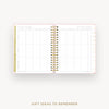 An open spiral-bound planner or notebook showing a gift ideas to remember tracking page, with a gold and black spiral binding, pink dotted borders, and a white page layout on a light gray background with the text 'GIFT IDEAS TO REMEMBER' below.