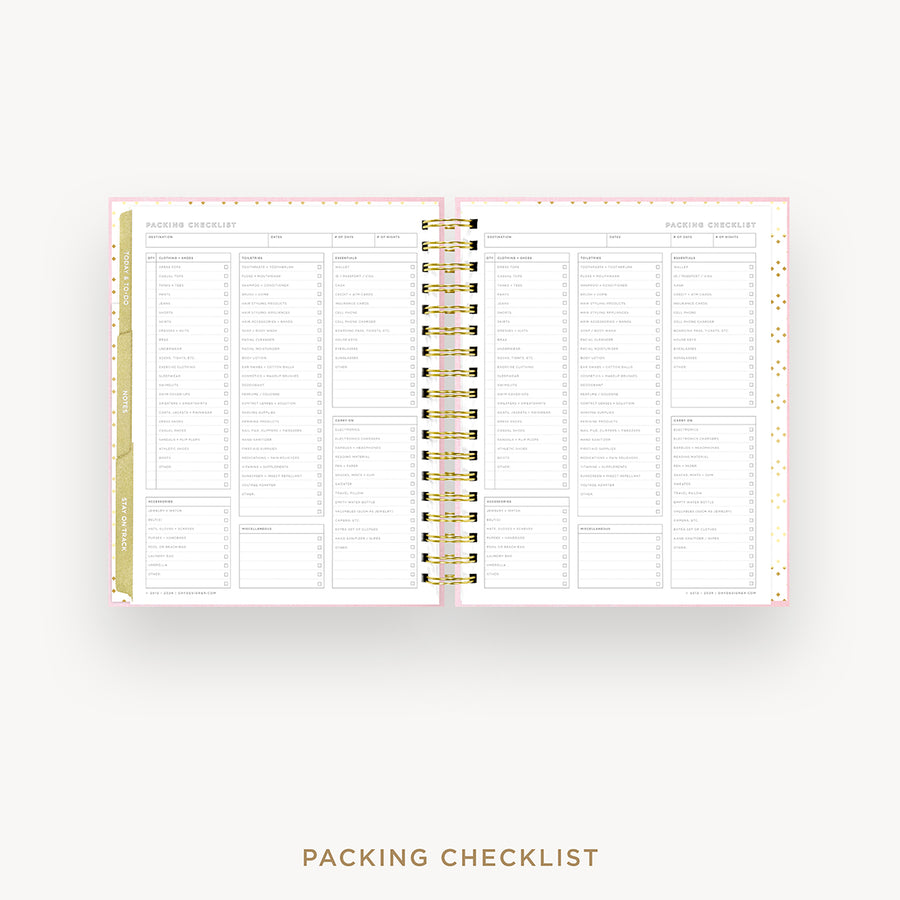 An open spiral-bound planner or notebook showing a packing checklist page spread, with pink and white pages and gold accents, on a light gray background. The text 'PACKING CHECKLIST' appears below.