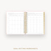 An open spiral-bound planner or notebook showing two printed goal-setting worksheet pages, with a gold ring binder and decorative pink and gold patterned edges, on a light gray background. Text below reads 'GOAL-SETTING WORKSHEETS'.