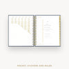Open planner showing daily layout with pocket, stickers, and ruler on a white background