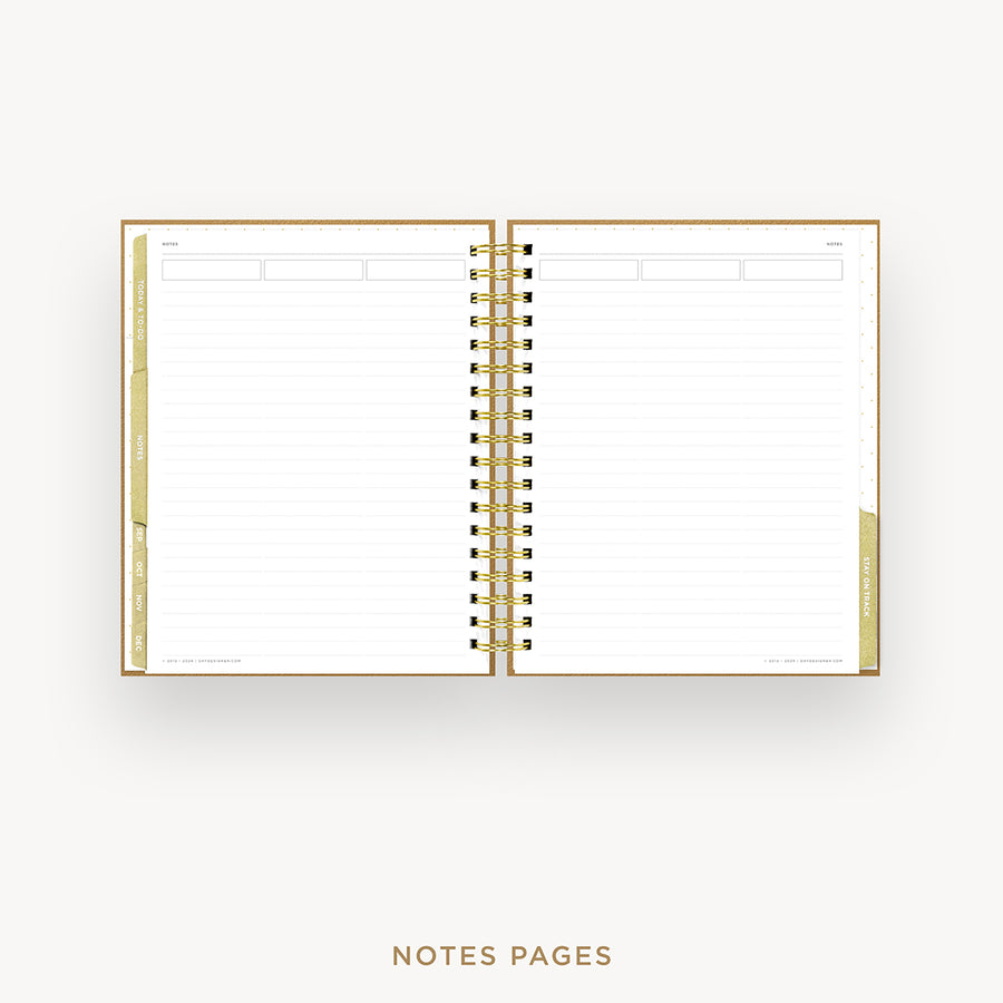 An open spiral-bound planner or notebook with lined notes pages, shown on a light gray background. The cover and binding are metallic gold, and the pages are white with faint horizontal lines.