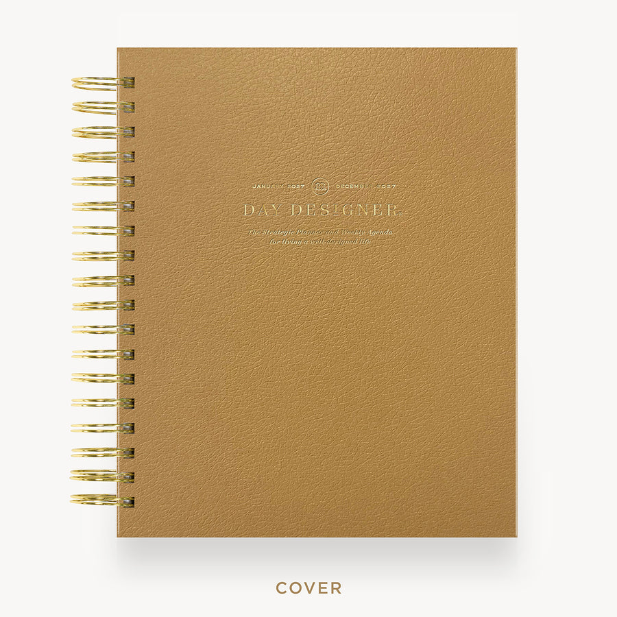 A tan textured spiral notebook with gold wire binding and gold foil lettering on the cover, shown against a white background with the word 'COVER' printed below.