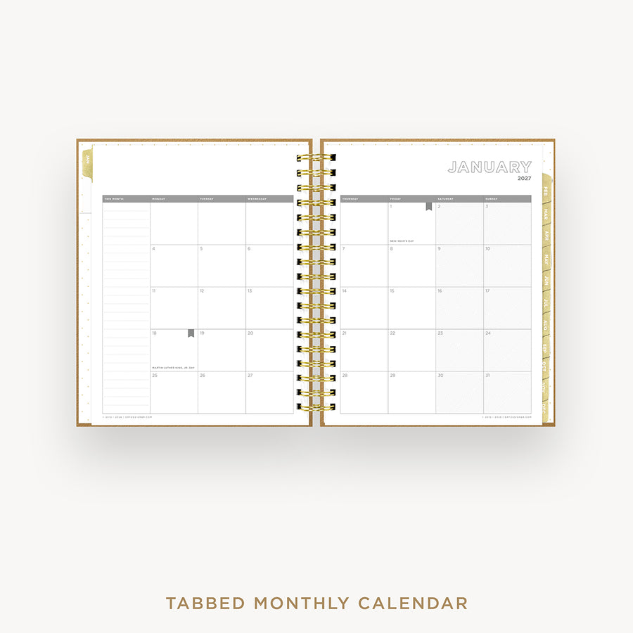 An open spiral-bound monthly calendar planner on a light gray background, showing a January 2027 calendar spread with tabbed pages and gold-toned binding. Text below reads 'TABBED MONTHLY CALENDAR'.