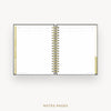An open spiral-bound planner or notebook showing lined notes pages with gold accents on the left and right margins, photographed on a light gray background with the text 'NOTES PAGES' below.