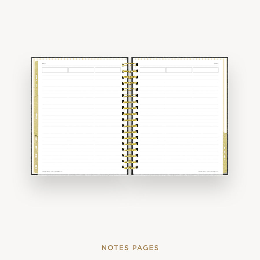 An open spiral-bound planner or notebook showing lined notes pages with gold accents on the left and right margins, photographed on a light gray background with the text 'NOTES PAGES' below.