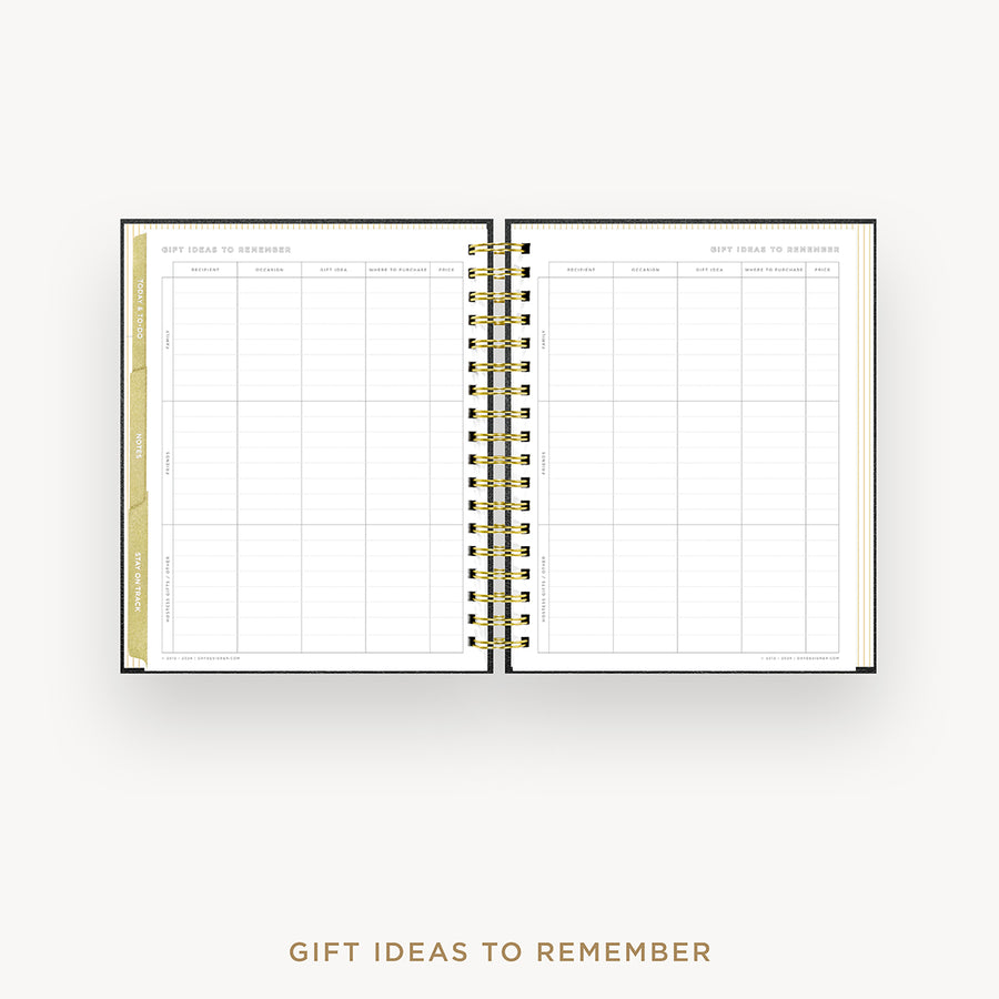 An open spiral-bound planner or notebook showing a gift ideas to remember grid page, photographed on a light gray background with the text 'GIFT IDEAS TO REMEMBER' below.